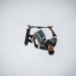 man in blue denim jacket and black pants riding on black skateboard